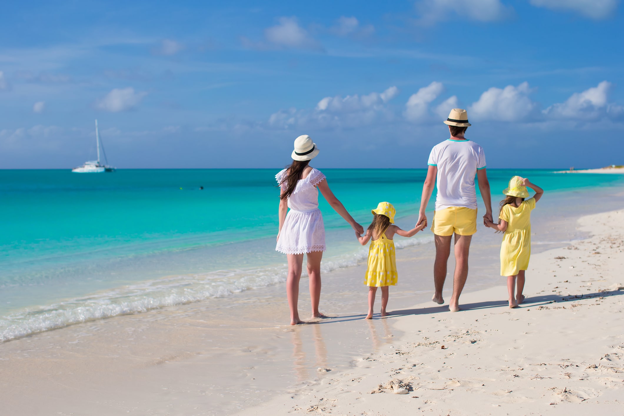 Family on a Caribbean beach celebrating the Royal Caribbean Sandals partnership news